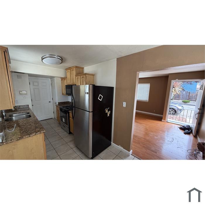 Kitchen with gas range, refrigerator and adjoining living area