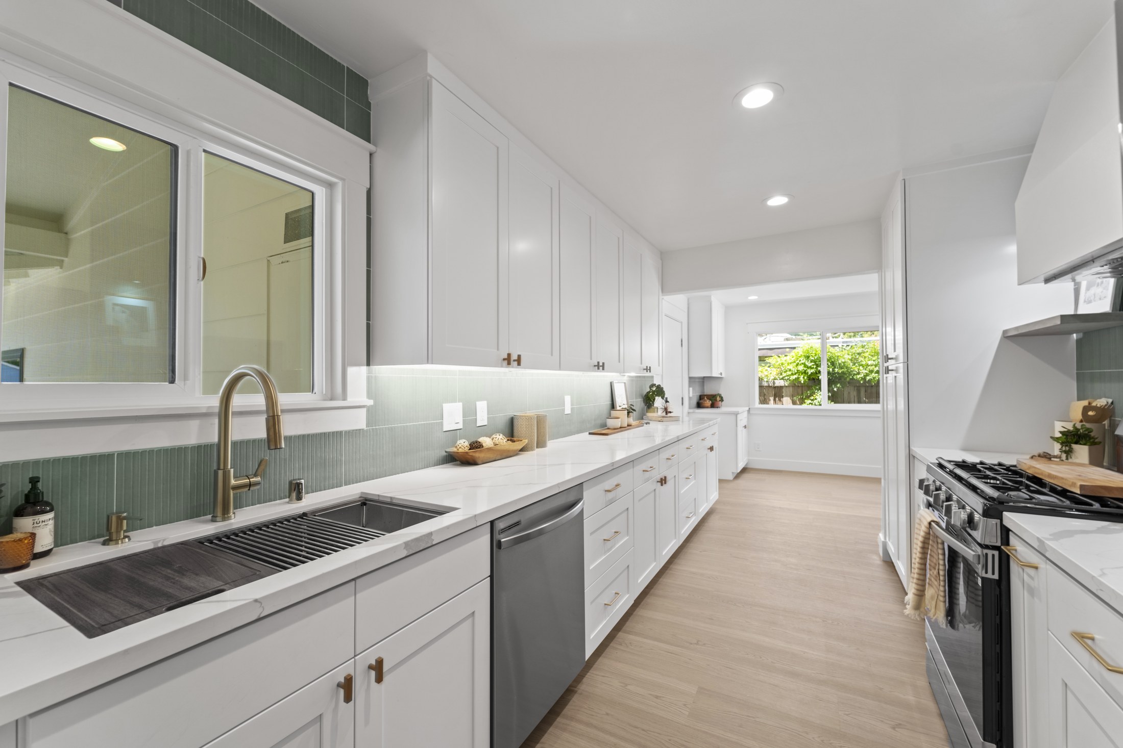 Bright galley kitchen with white cabinetry
