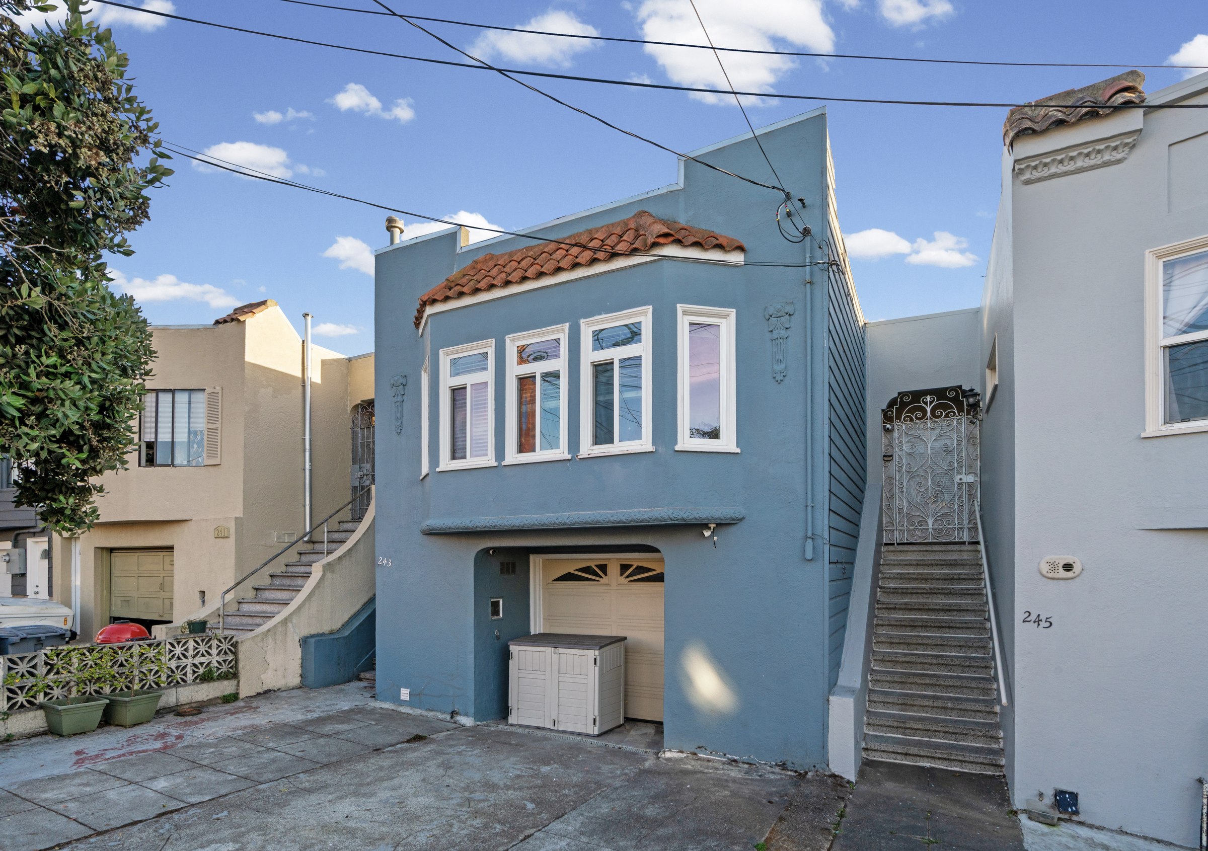 Blue facade, bay windows and front entrance at 243 Farallones Street