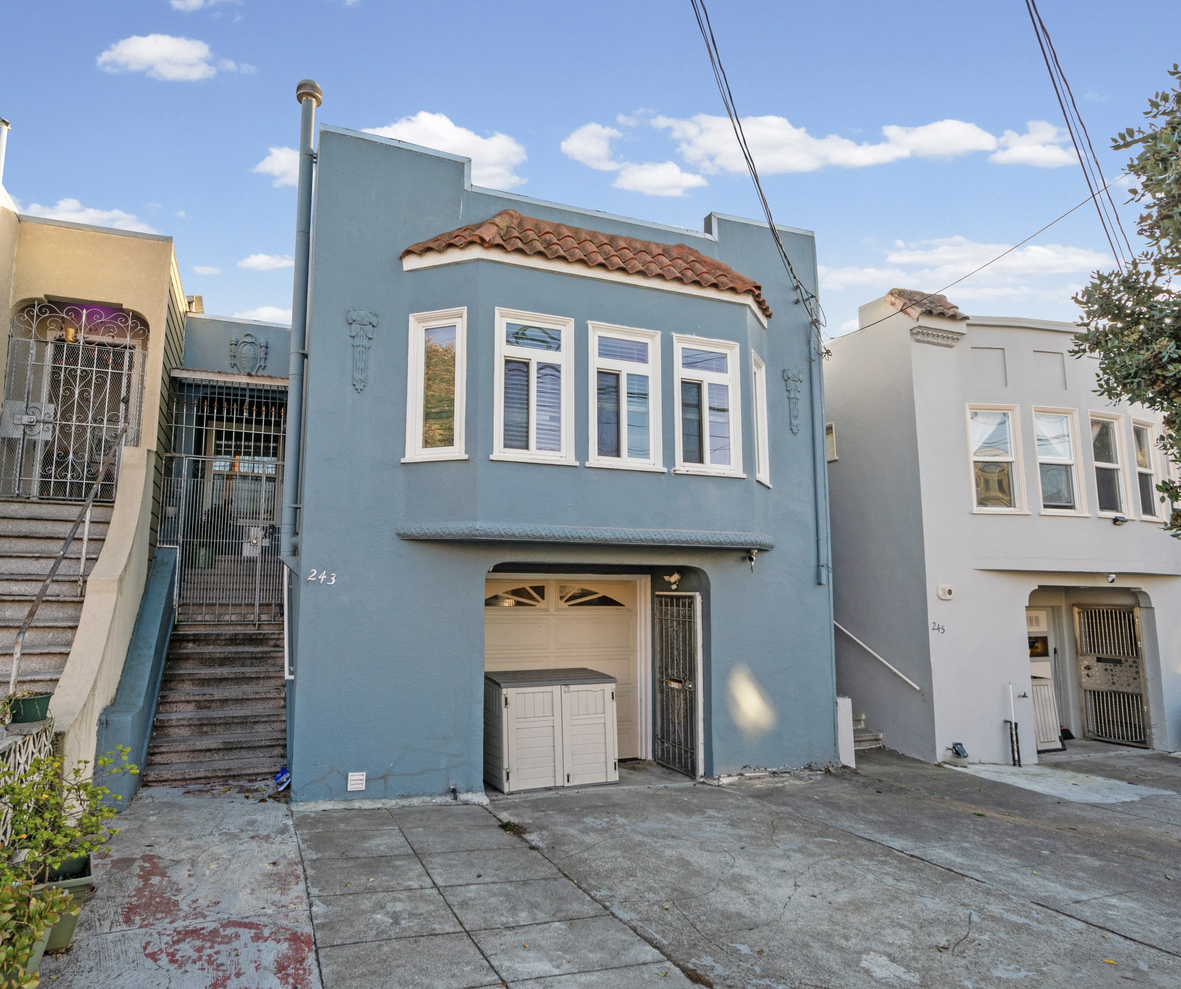 Blue facade, bay windows and front entrance at 243 Farallones Street