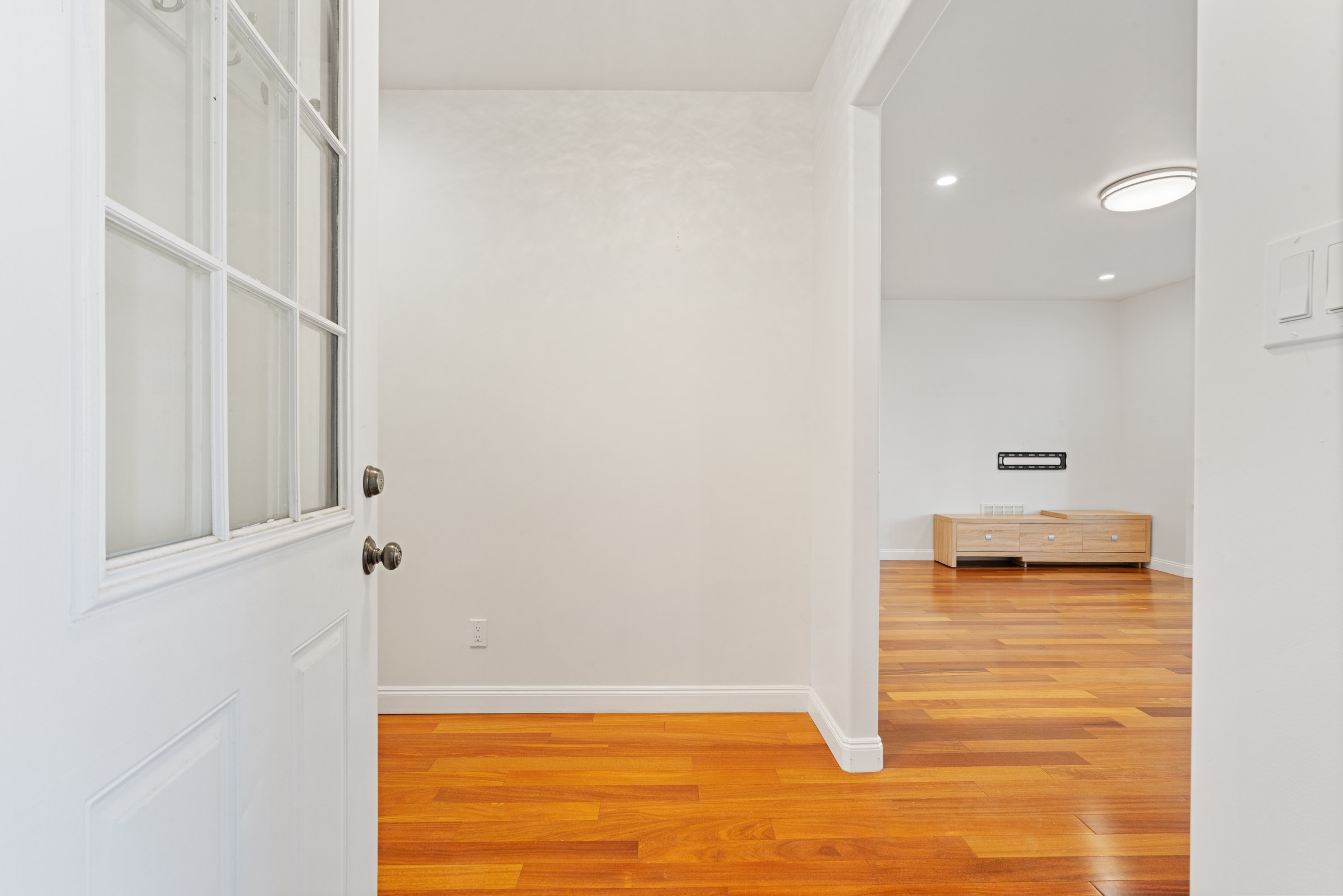 Upper residence living and dining area with warm-toned wood floors