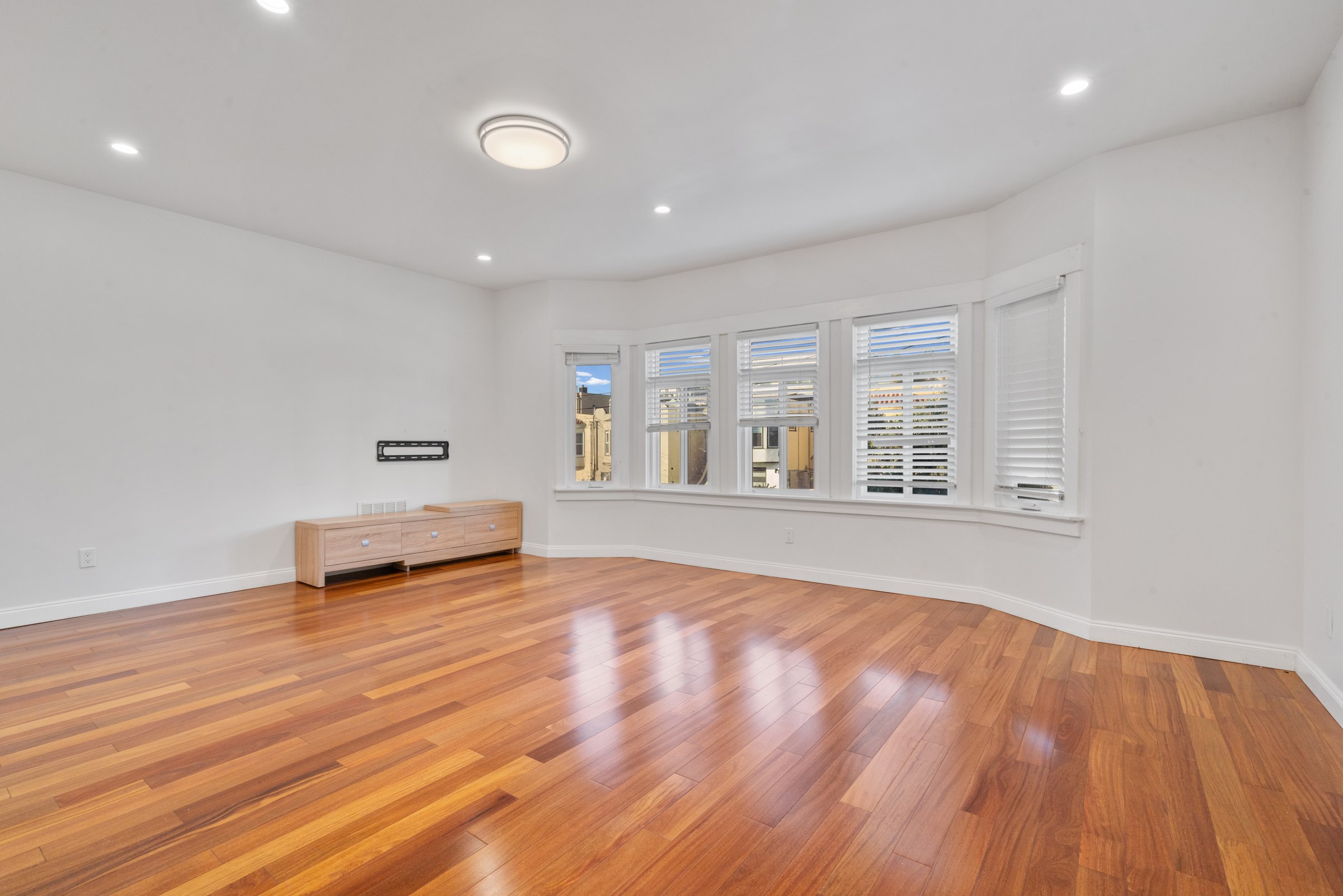 Upper residence living and dining area with warm-toned wood floors