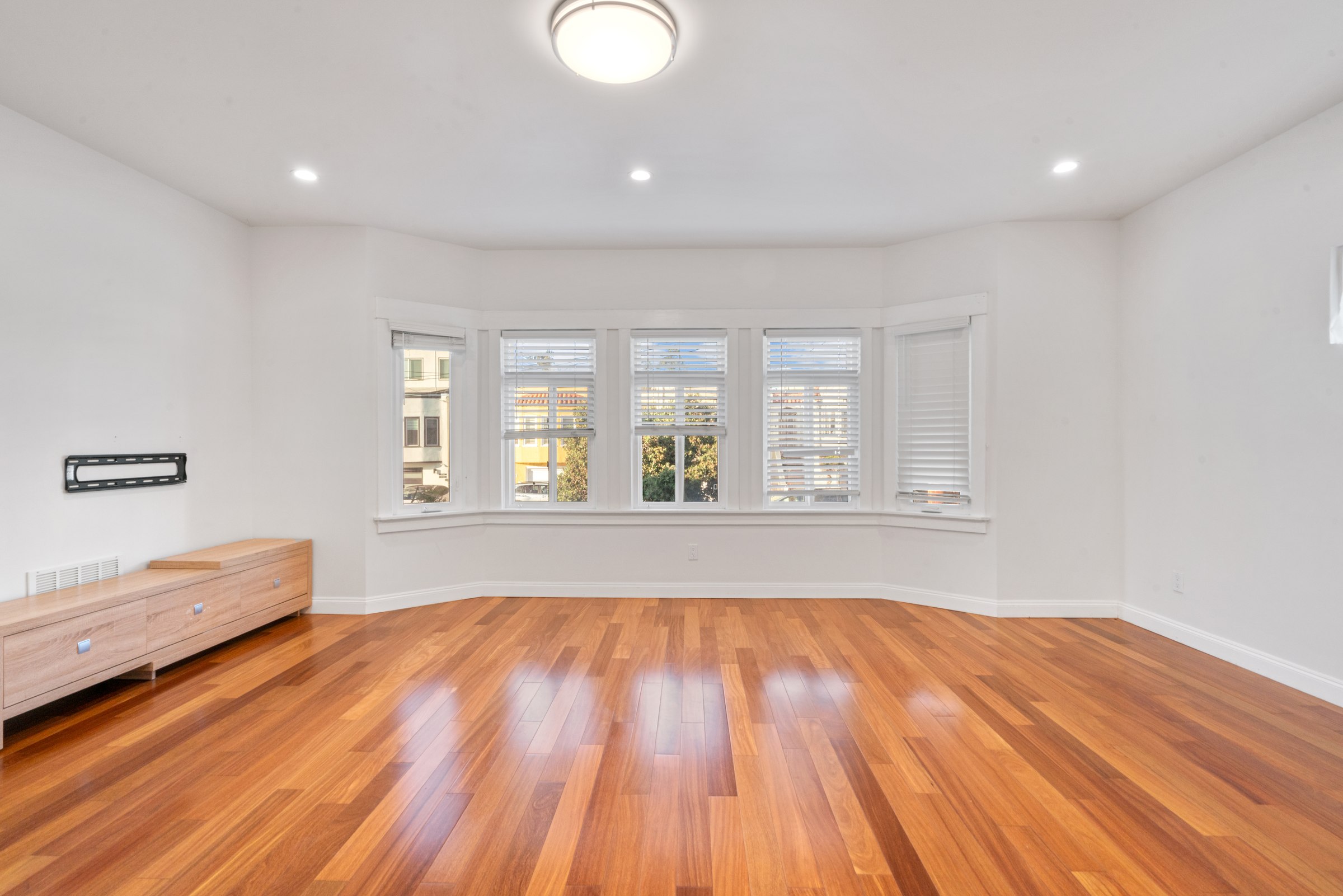 Upper residence living and dining area with warm-toned wood floors