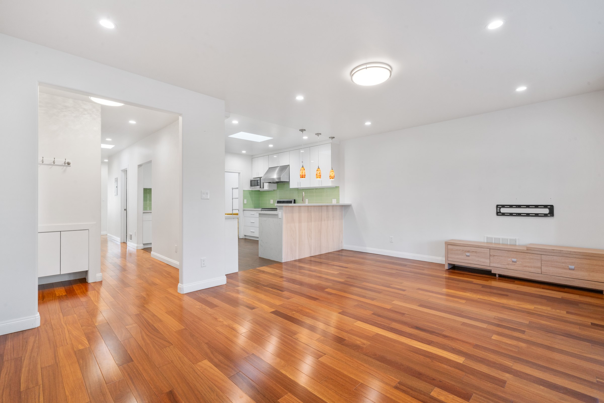 Upper residence living and dining area with warm-toned wood floors