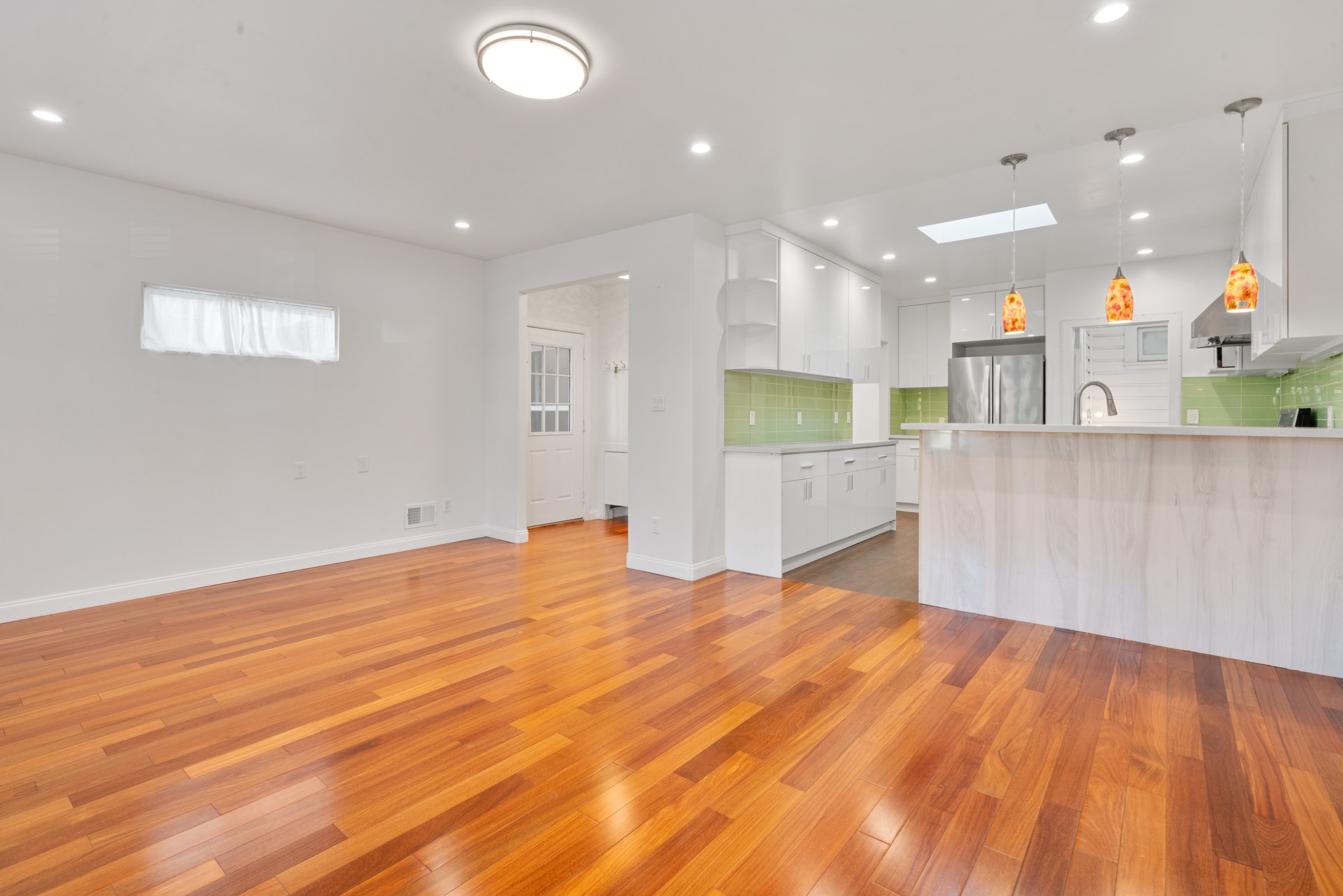 Upper residence living and dining area with warm-toned wood floors