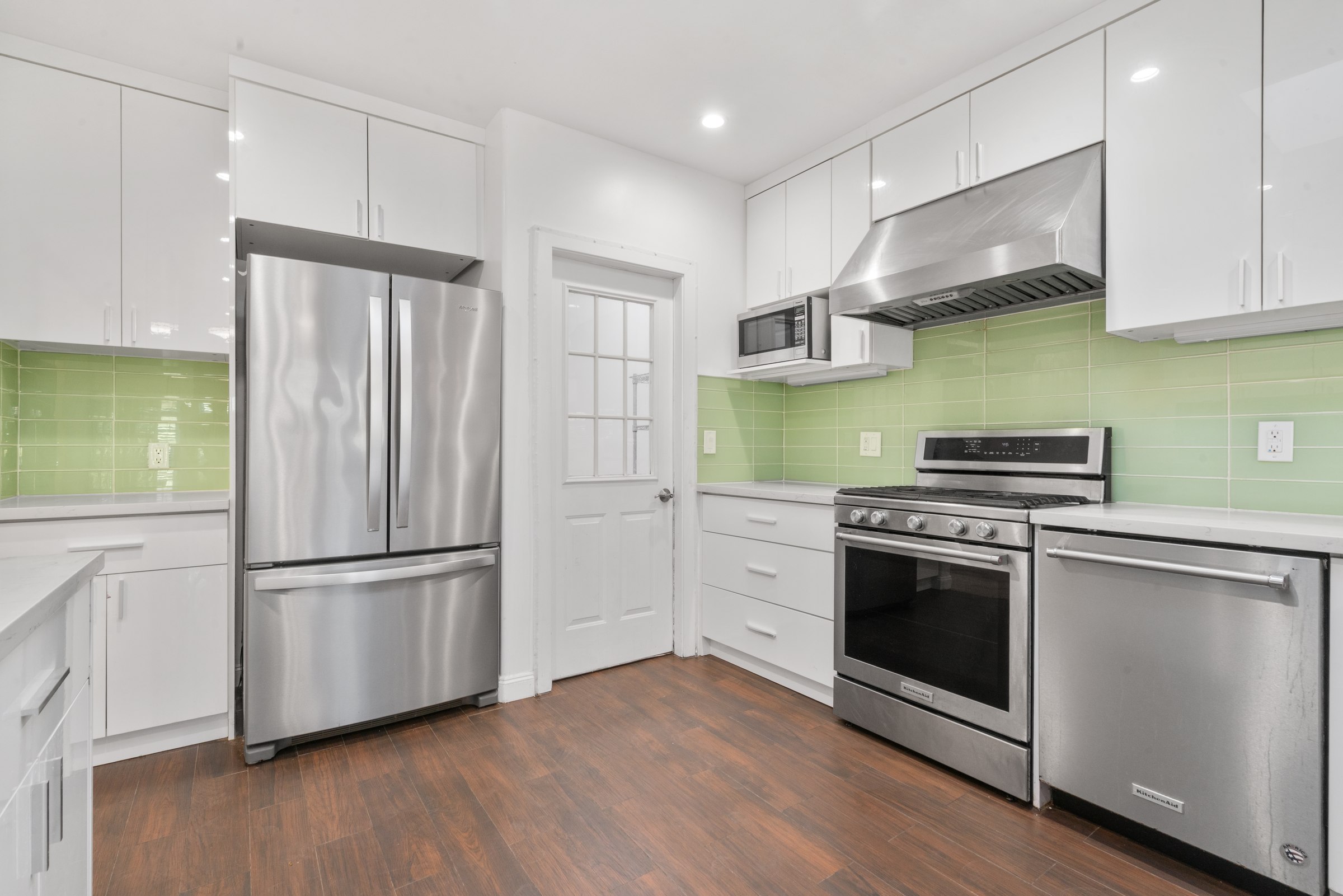 White cabinetry, green backsplash and stainless steel appliances