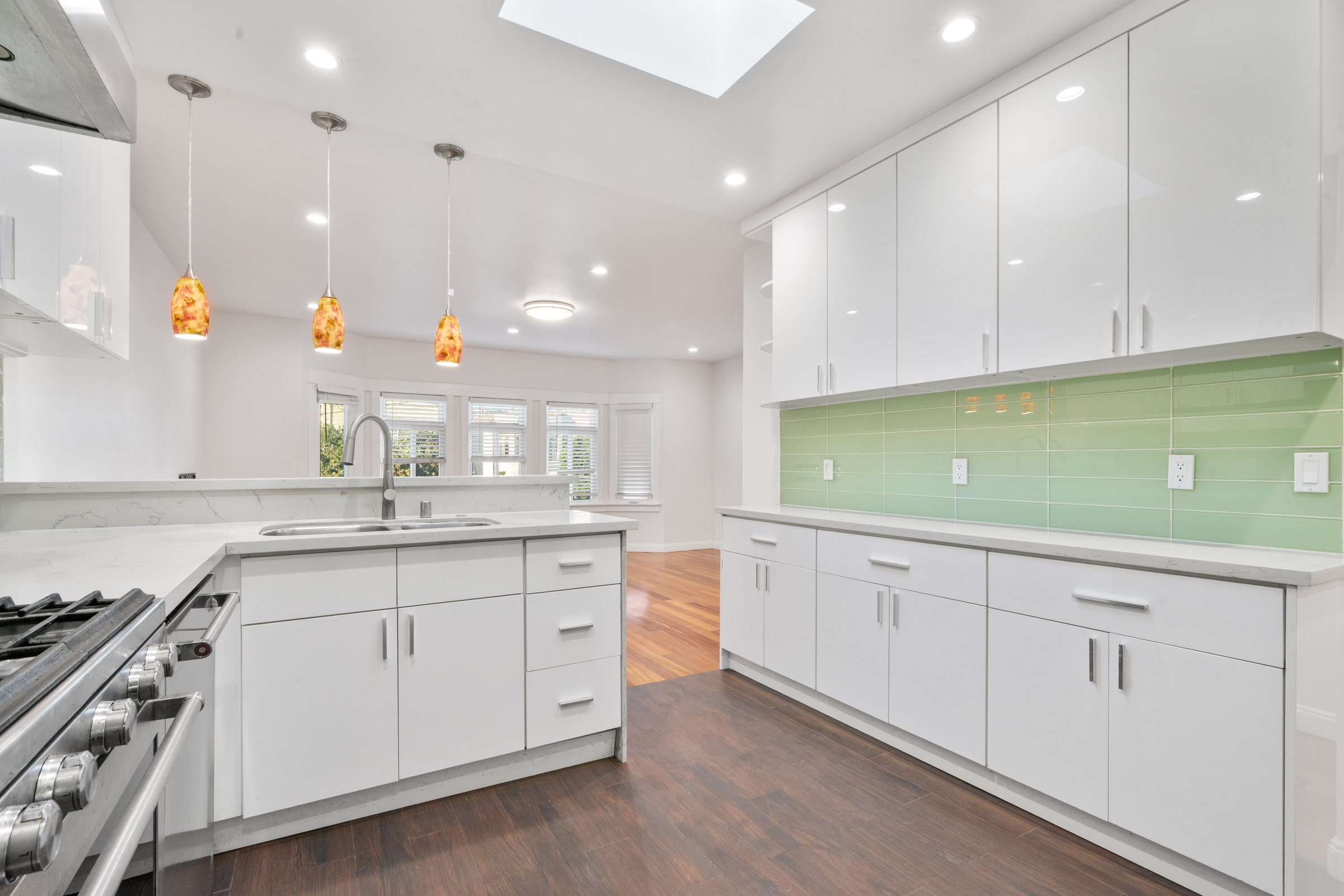 White cabinetry, green backsplash and stainless steel appliances